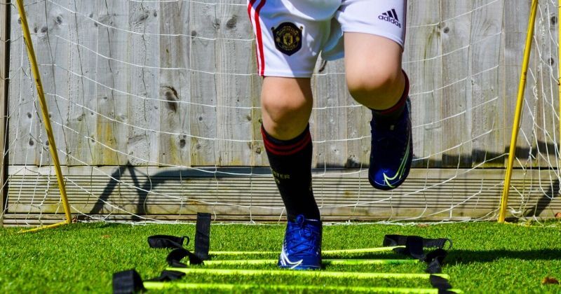 child doing football drills in the garden