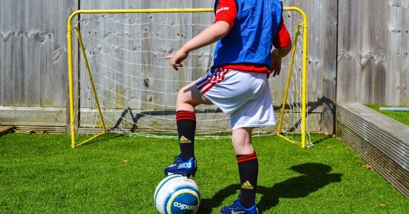 child lines up a penalty in the back garden