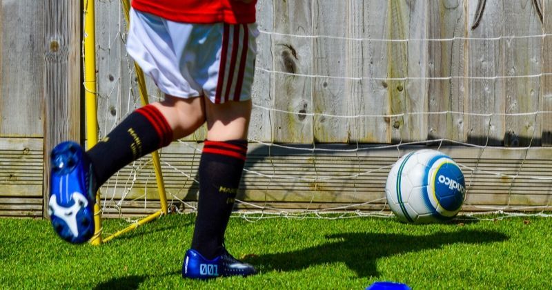 child scoring a goal in the garden