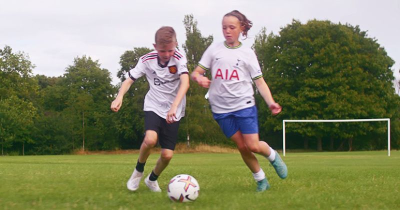 two children battling for control of a football