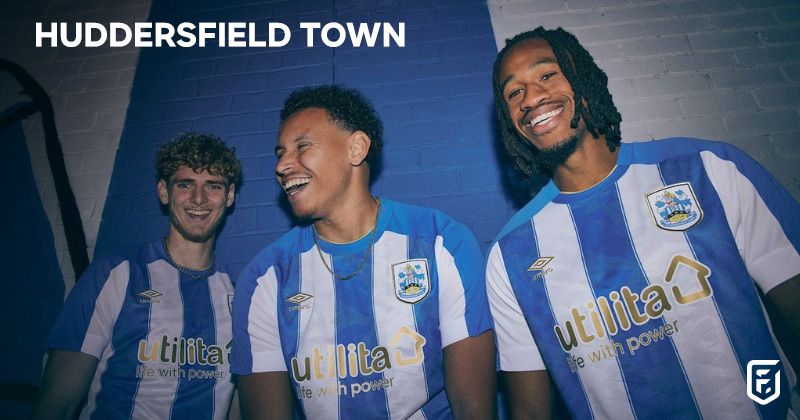 three players wearing huddersfield town 2023-24 home shirt in blue and white stripes